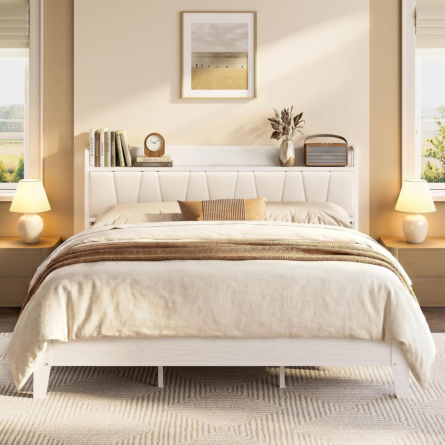 Straight-on view of a white platform bed with a tufted headboard shelf, neutral bedding and bedside lamps.