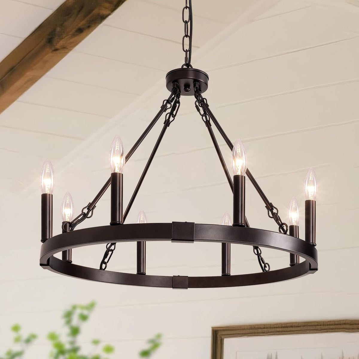 Upward view of dark metal orb chandelier ring with lit candle bulbs and a wooden ceiling beam.