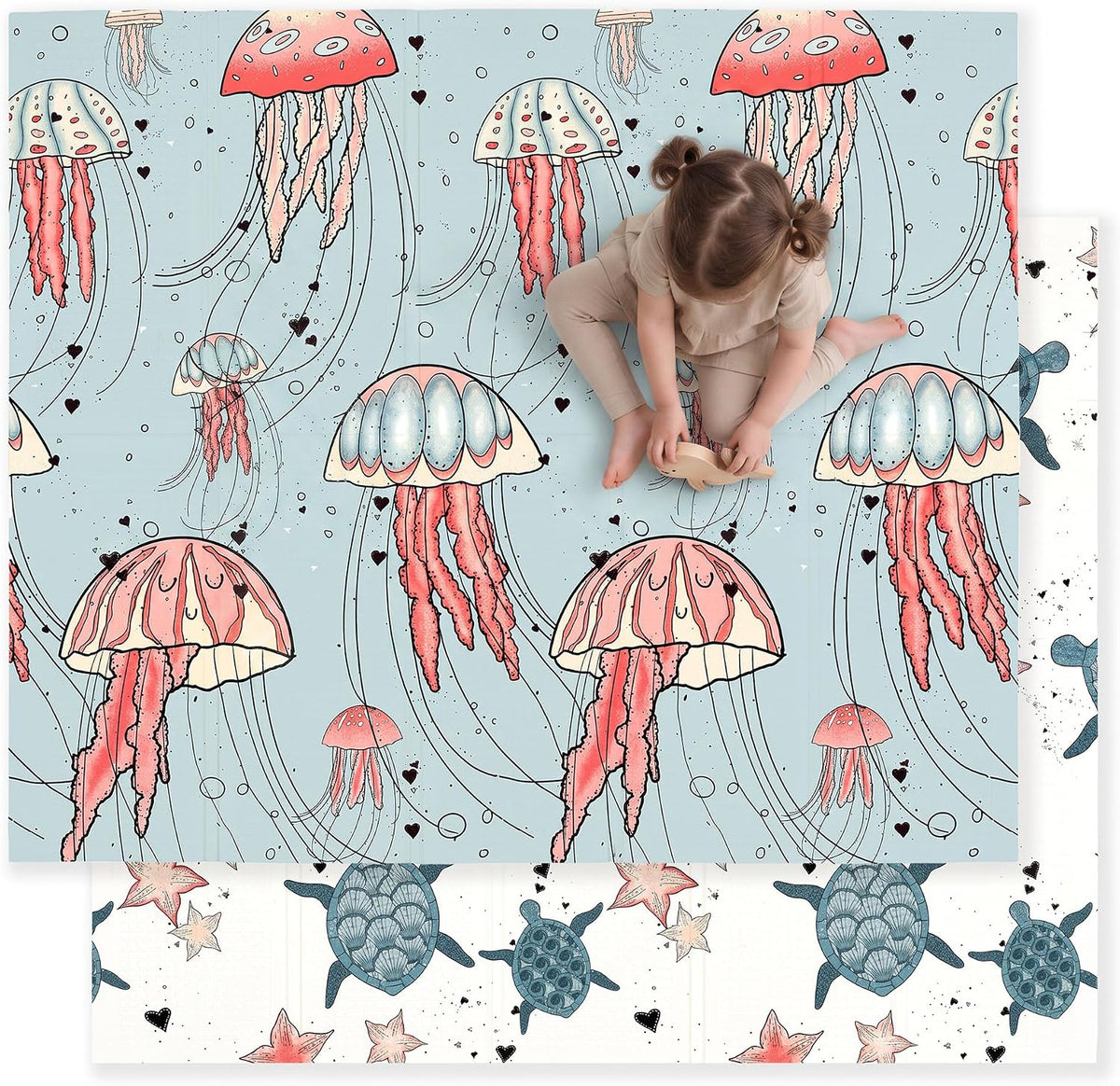 Overhead view of a toddler playing on a light blue play mat printed with large pink jellyfish; a turtle-and-star mat peeks