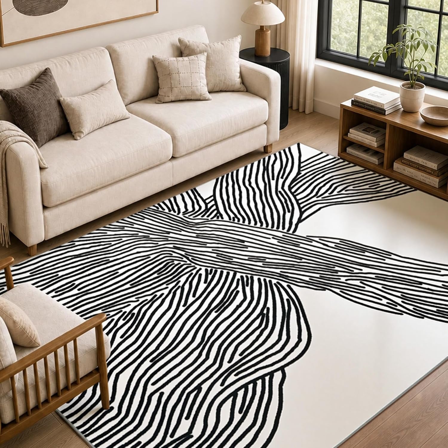 Angled close view of the black-and-white abstract rug next to a cream sofa, wooden armchair and low media shelf.