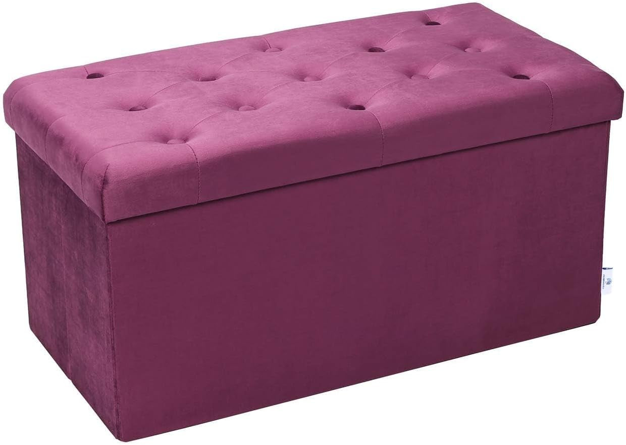 Angled view of a long rectangular magenta tufted storage bench with lid