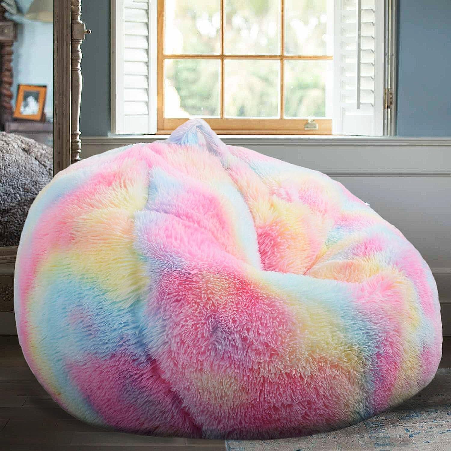 Pastel rainbow faux-fur round bean bag chair in a bright bedroom by a window