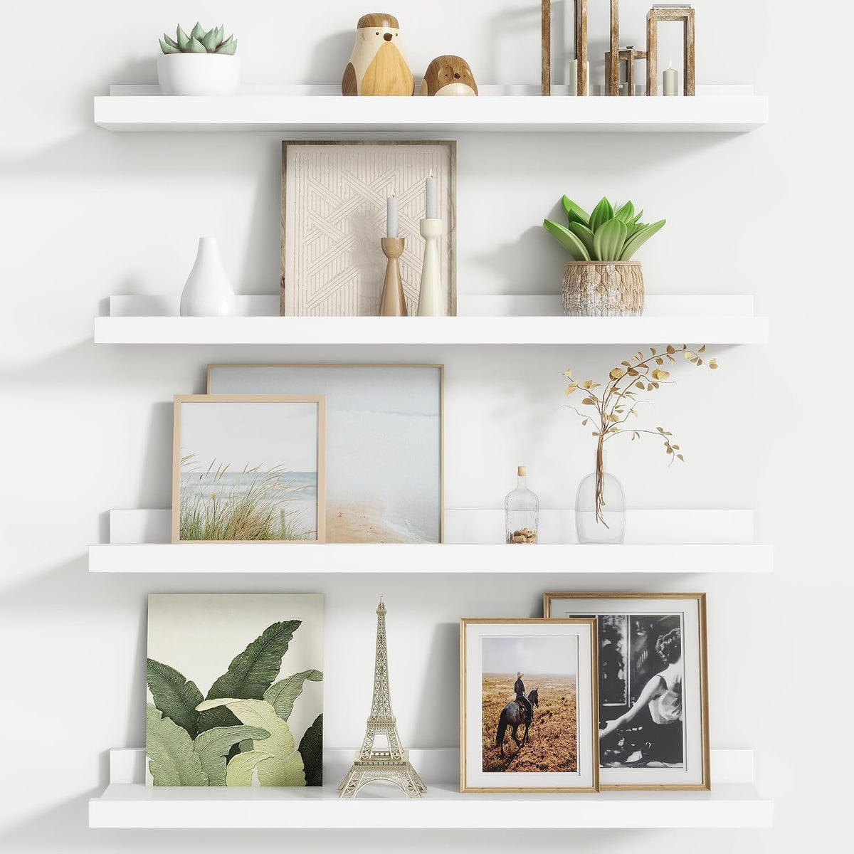 Three white floating picture ledges shown with neutral artwork, candlesticks and a potted plant.
