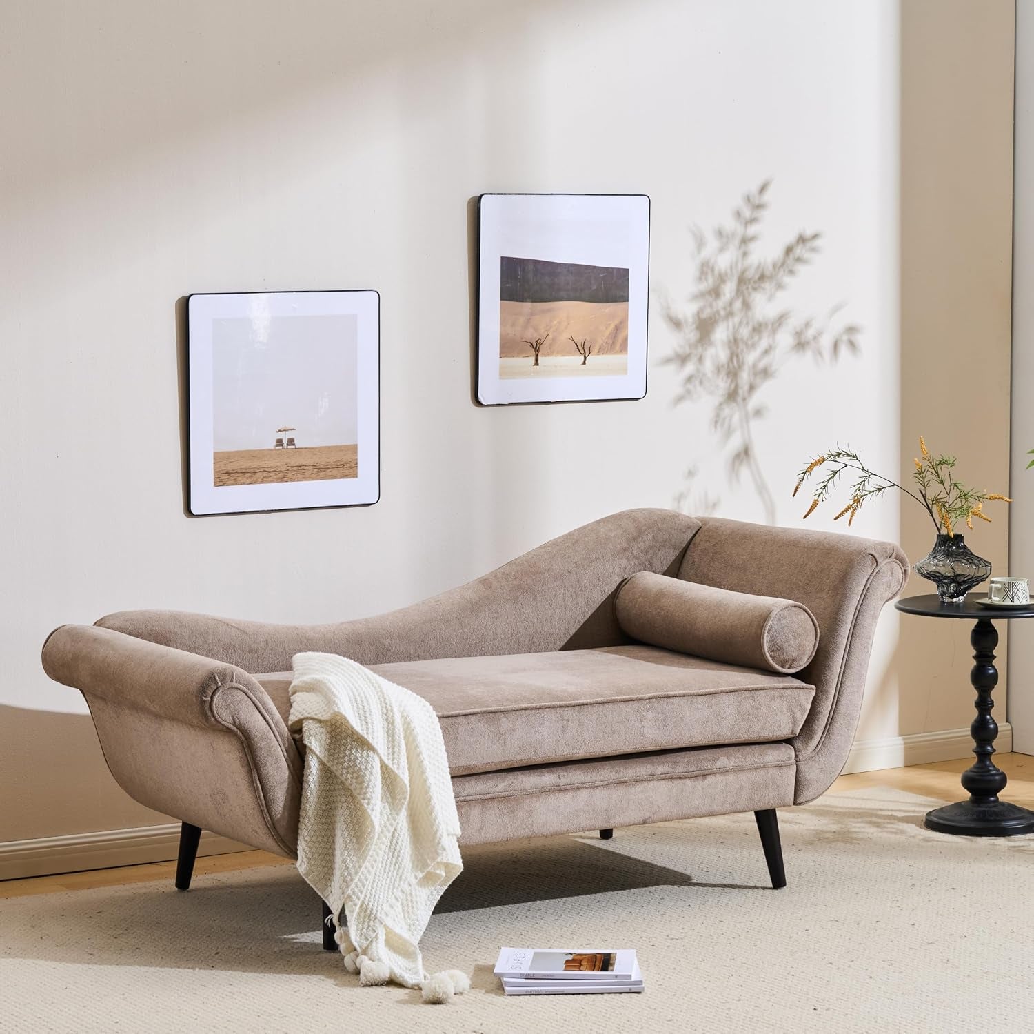Light brown velvet chaise lounge with rolled arms, bolster pillow and cream throw in a staged living room.