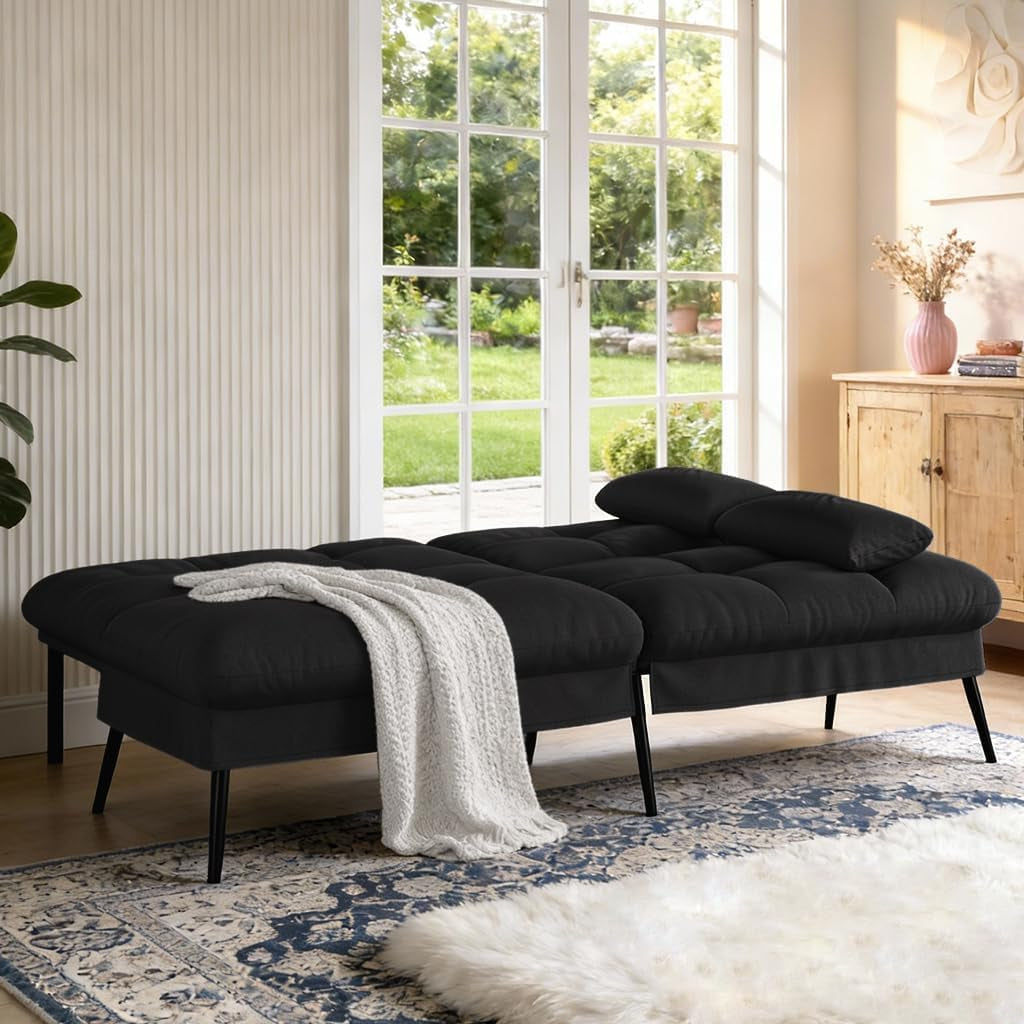 Black futon shown fully reclined into a flat bed position with a throw draped on top