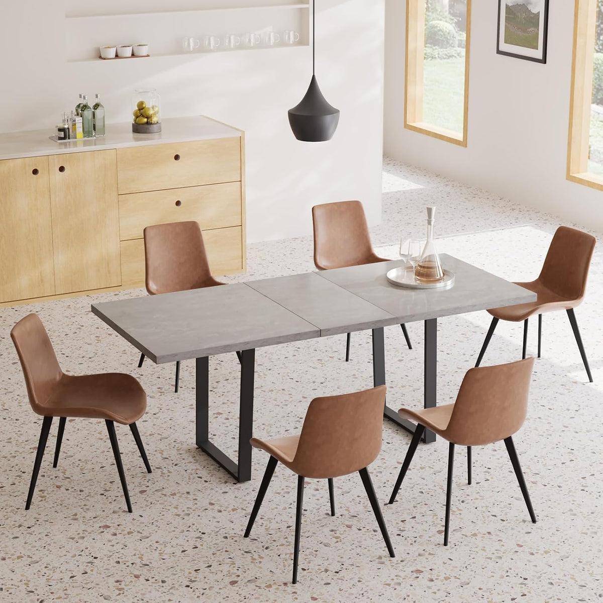 Three-quarter overhead of the extended gray table with brown chairs, terrazzo floor and a light wood sideboard.