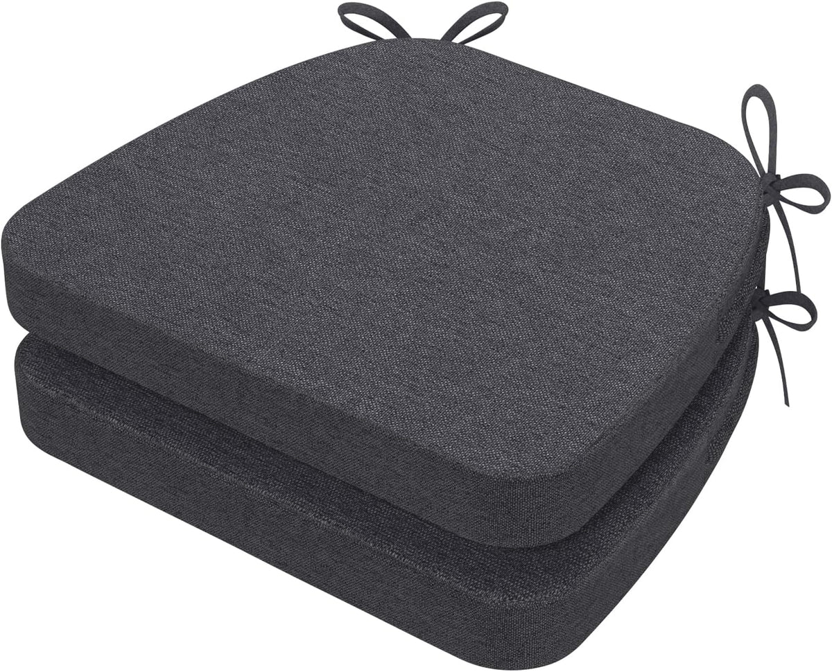 Two stacked dark charcoal gray D-shaped chair cushions shown from an angle with tied loops