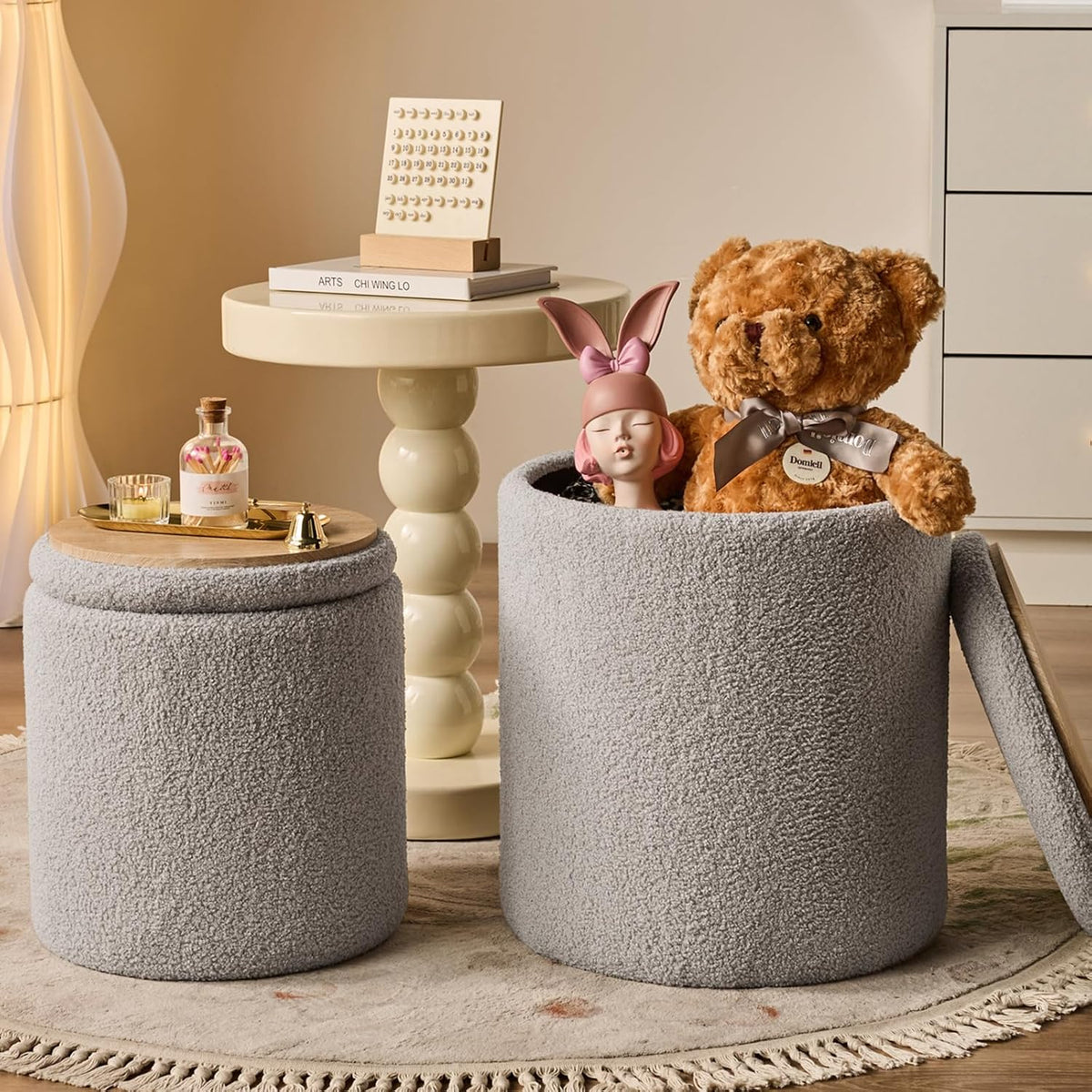 Close view of light gray round ottomans in a room, one open with toys inside and a wood-top placed on the other