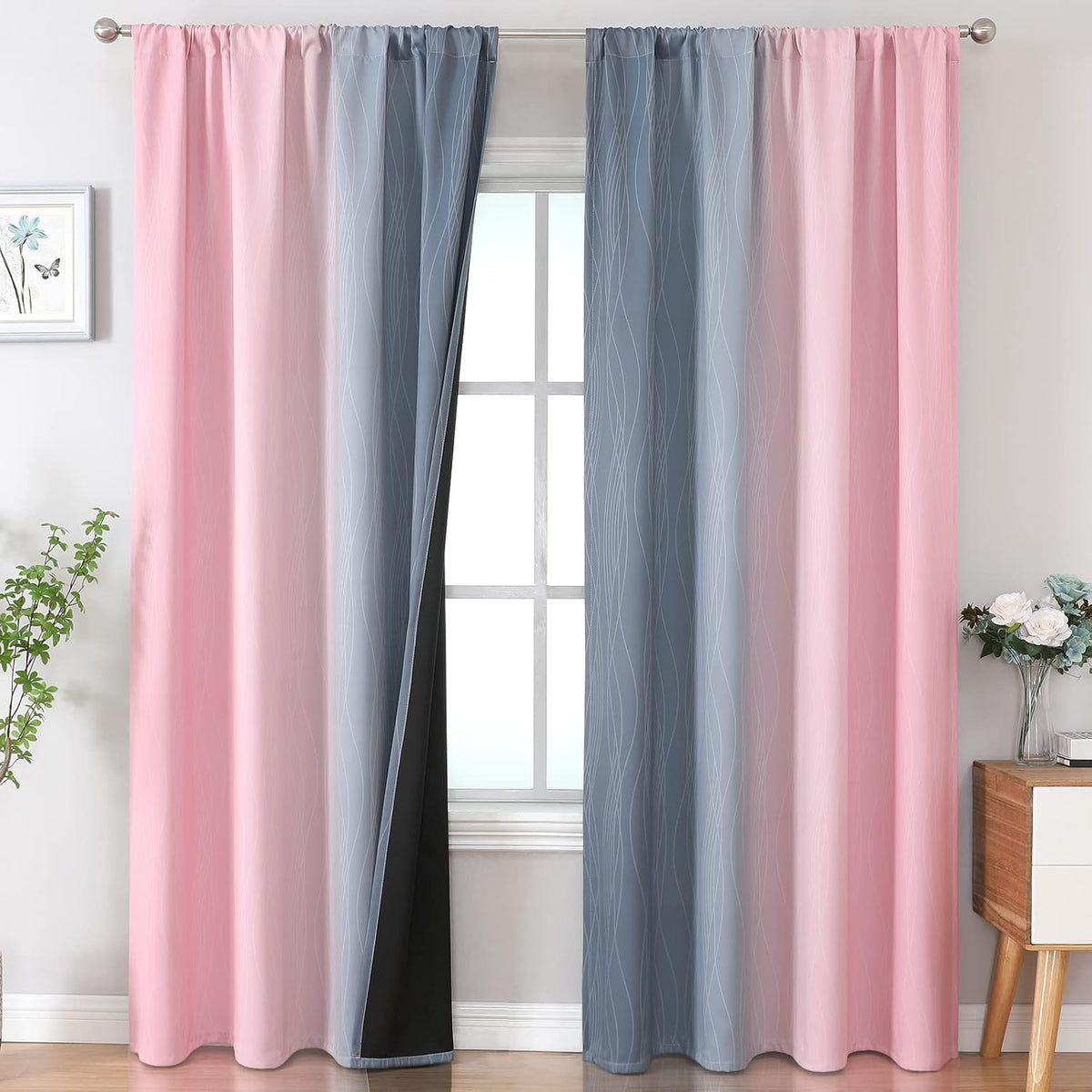 Pair of pink-to-gray ombre curtain panels with wavy line print, one panel pulled back to show black lining