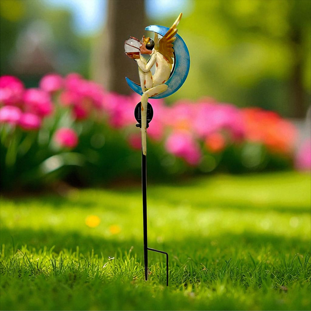 Side view of a winged angel holding a small object, with a blue crescent behind it on a garden stake.