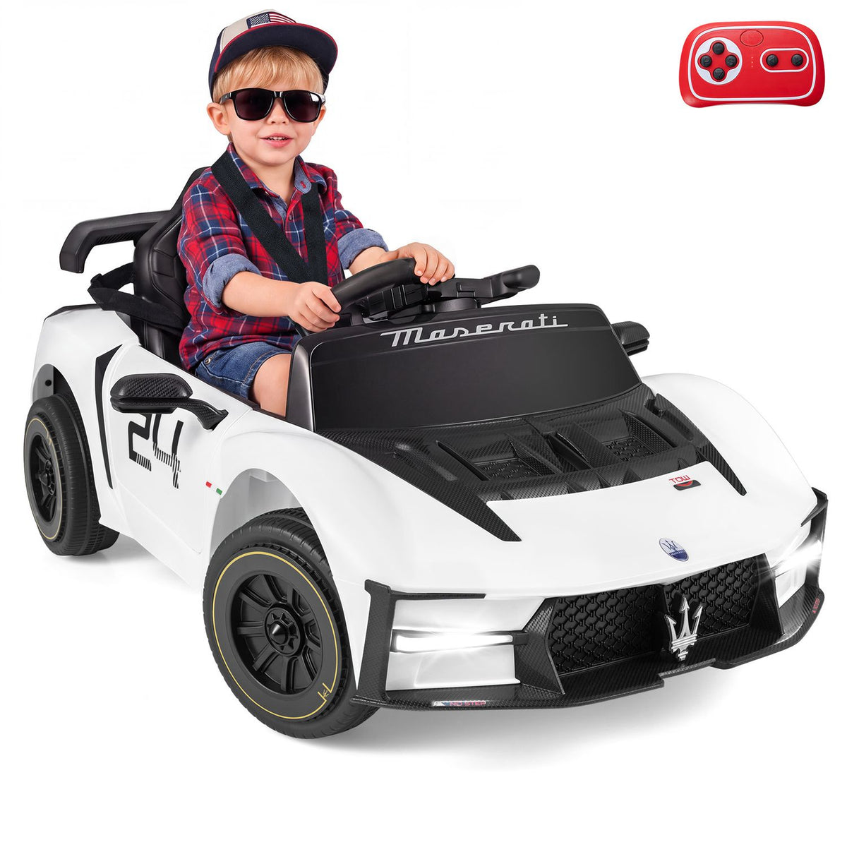 A child wearing sunglasses sits behind the wheel of a white ride-on car.