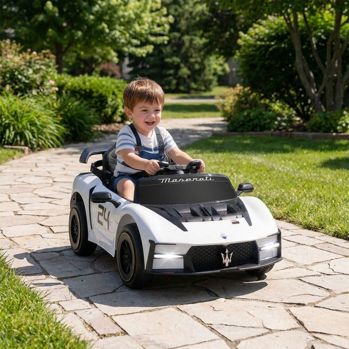 A child drives a small white ride-on car along a garden path.