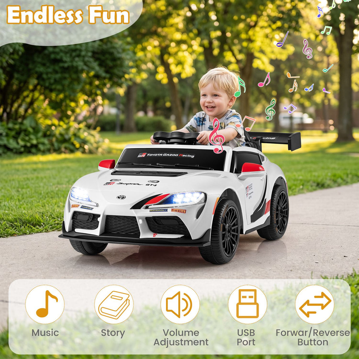 A smiling child steers a white ride-on car along a paved path beneath trees.