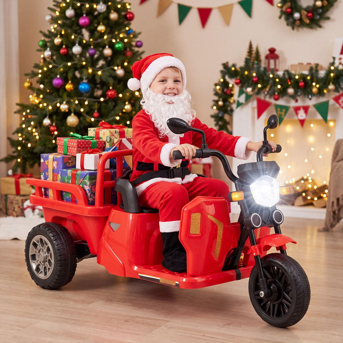 A child dressed as Santa rides a red three-wheeled toy with a trailer full of wrapped gifts indoors.