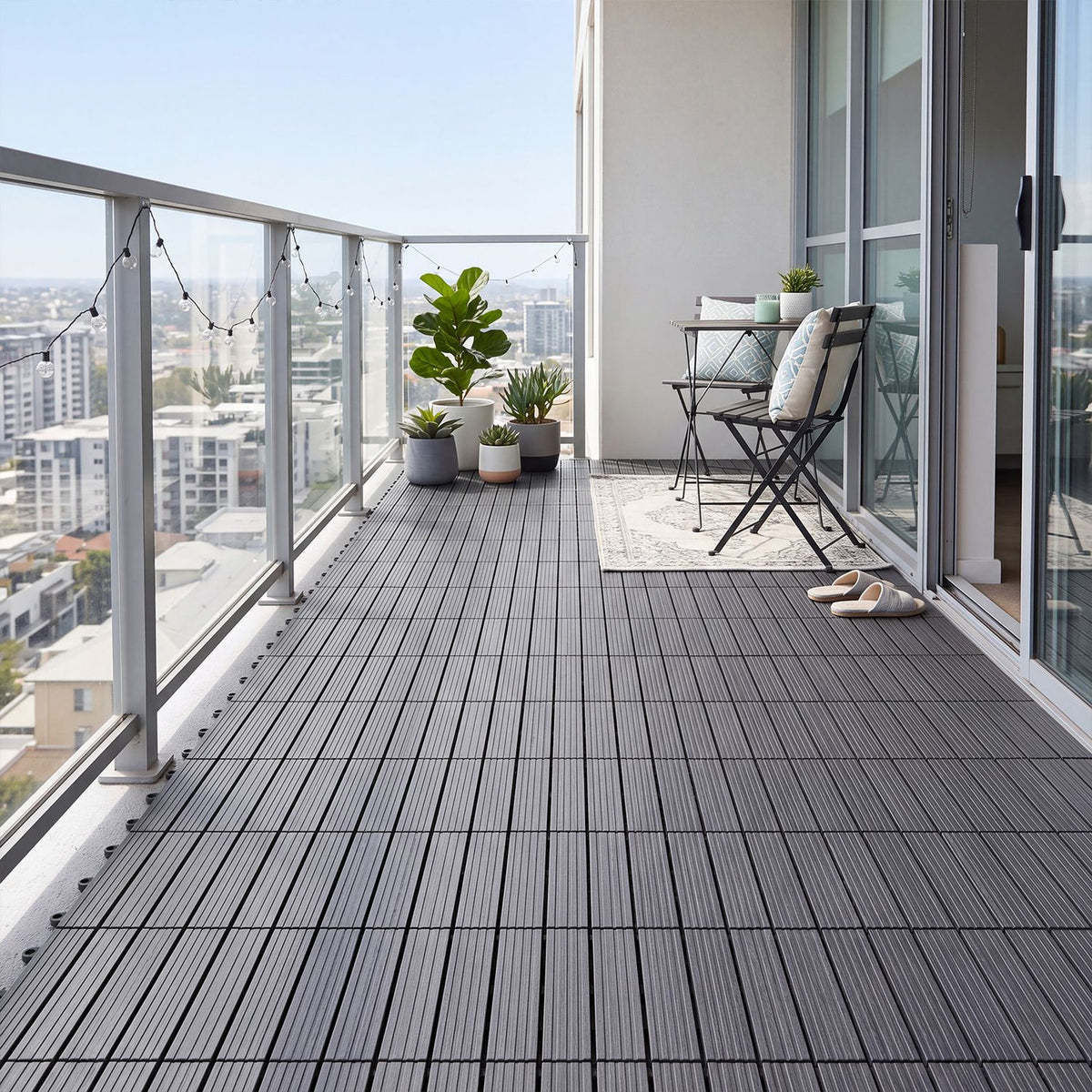 Gray interlocking deck tiles covering a modern balcony beside outdoor seating