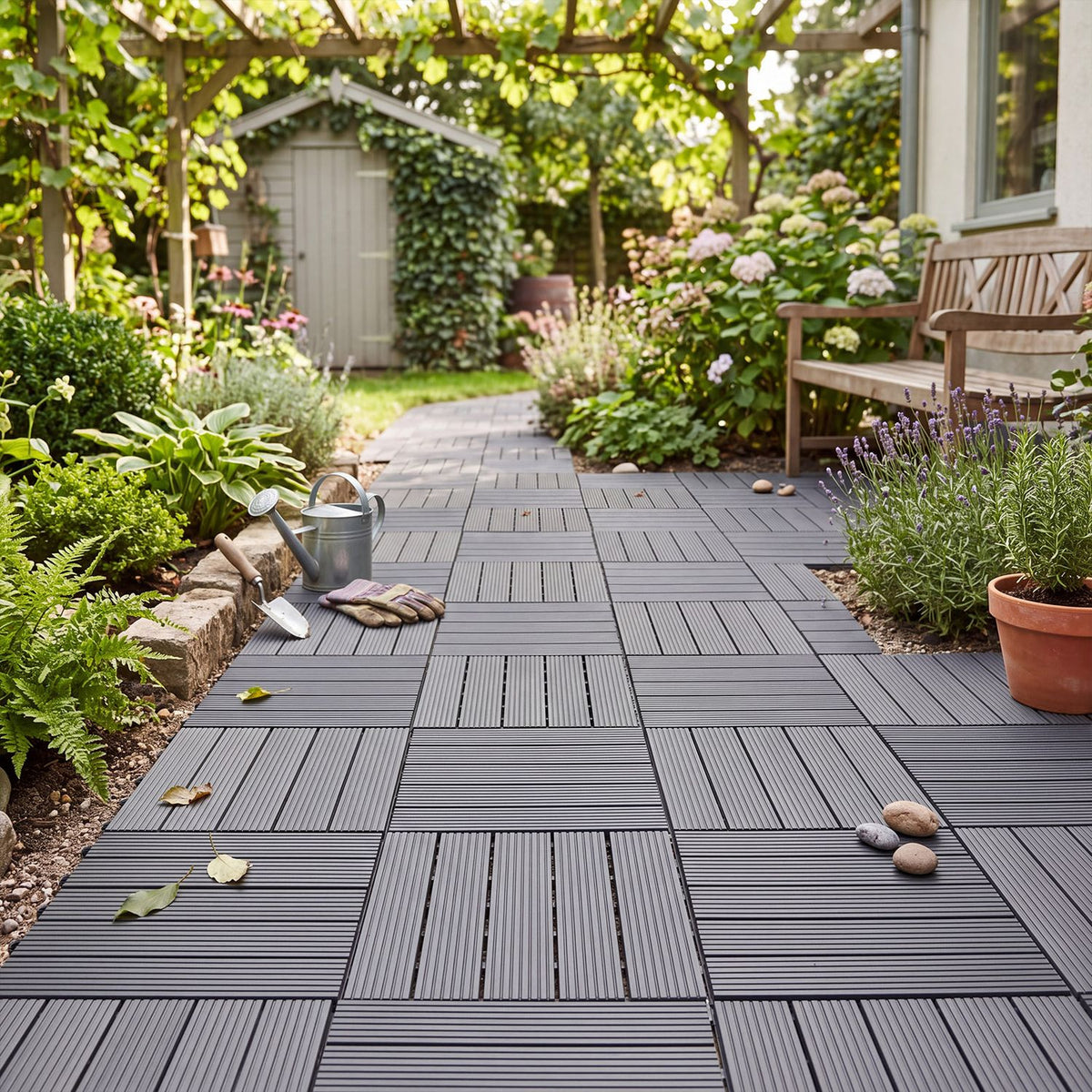 Gray deck tiles arranged along a garden path among plants and pots
