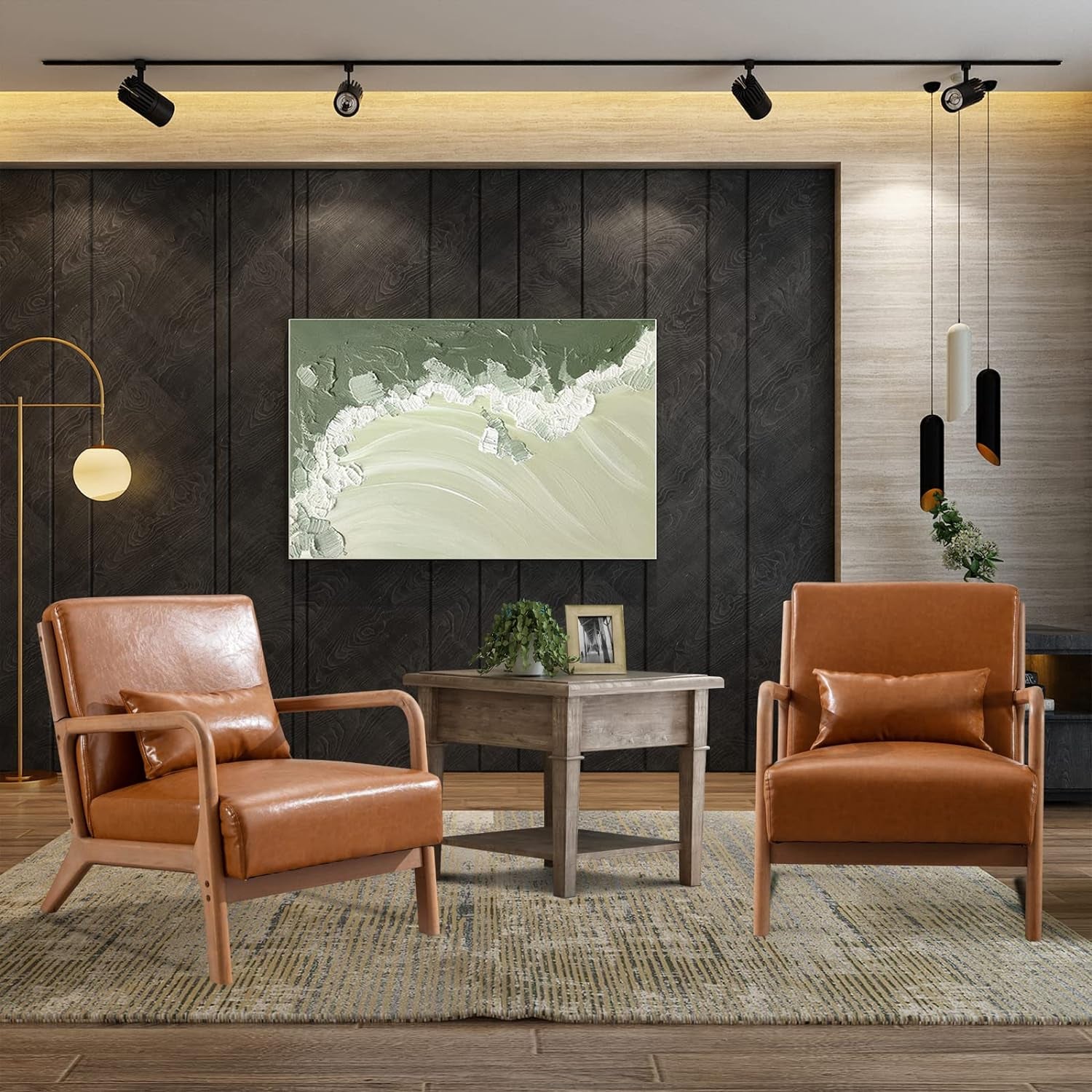 Two tan leather armchairs flanking a small wooden coffee table against a dark wood accent wall.