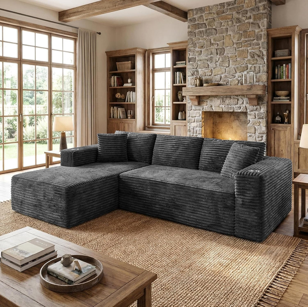 Dark gray ribbed sectional with a left chaise and pillows in a rustic living room.