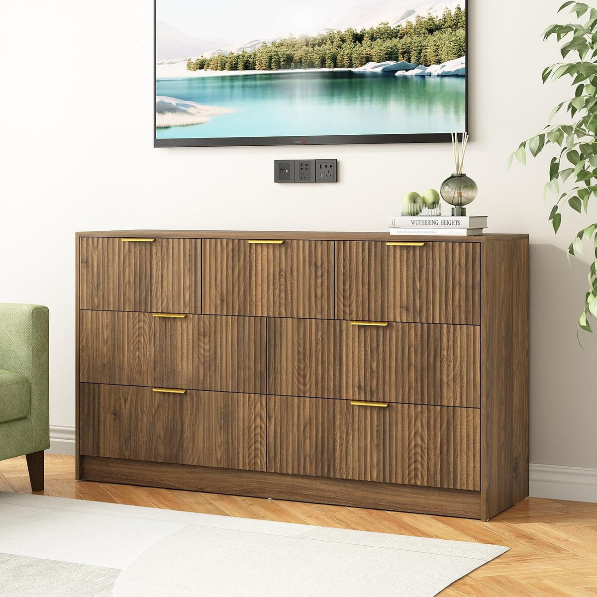Straight-on view of a nine-drawer walnut dresser with gold handles beneath a wall-mounted TV.