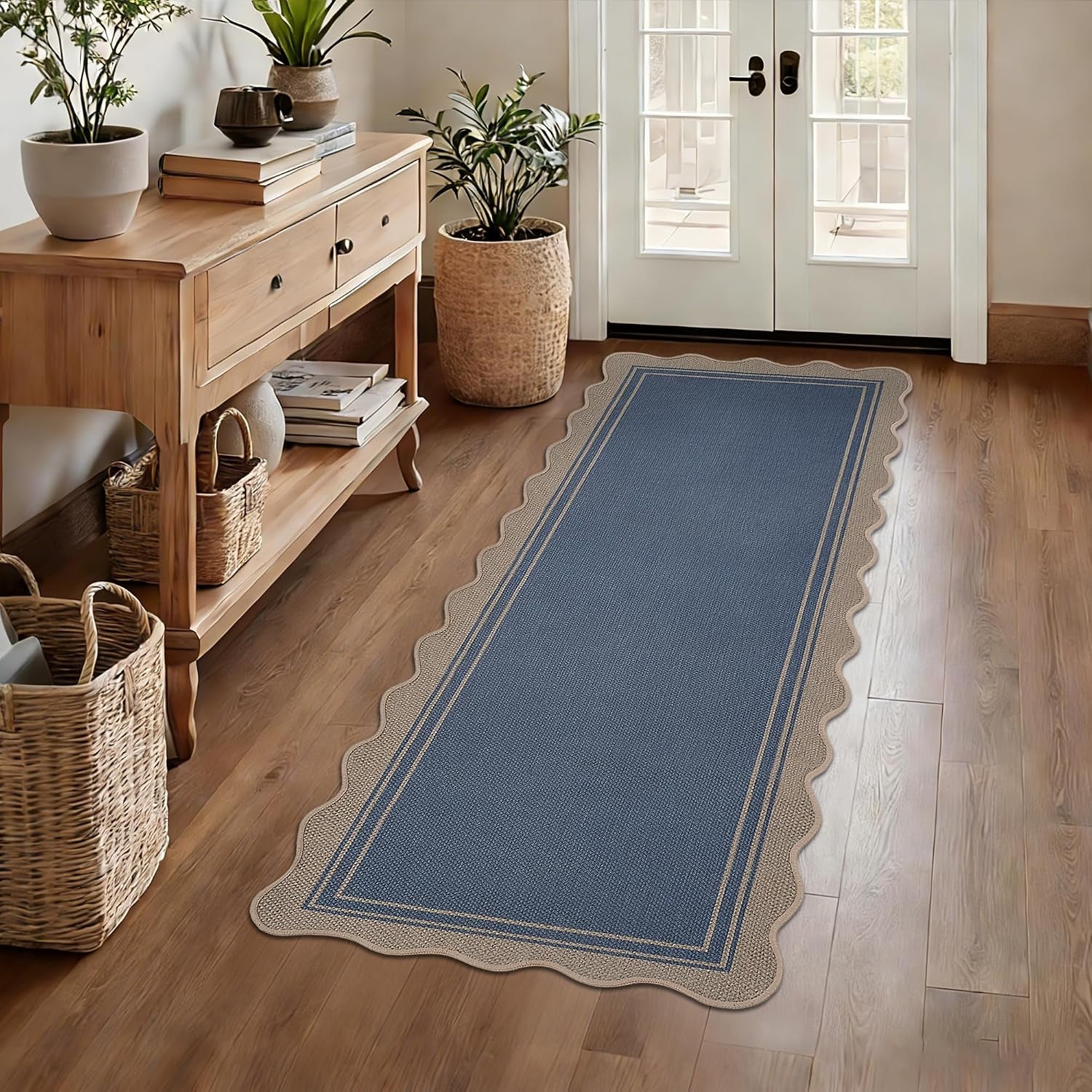 Narrow hallway with scalloped blue runner rug and wooden console table and baskets.