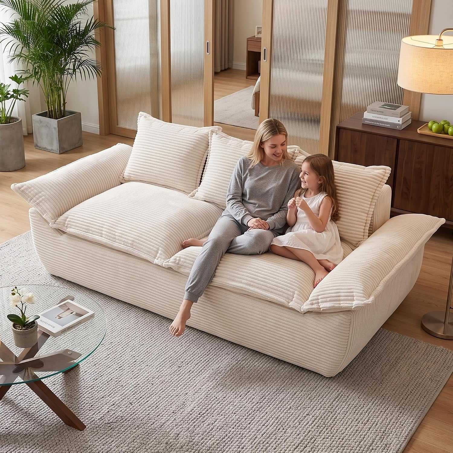 Low-angle living room shot of a cream corduroy two-seater with two people sitting on it