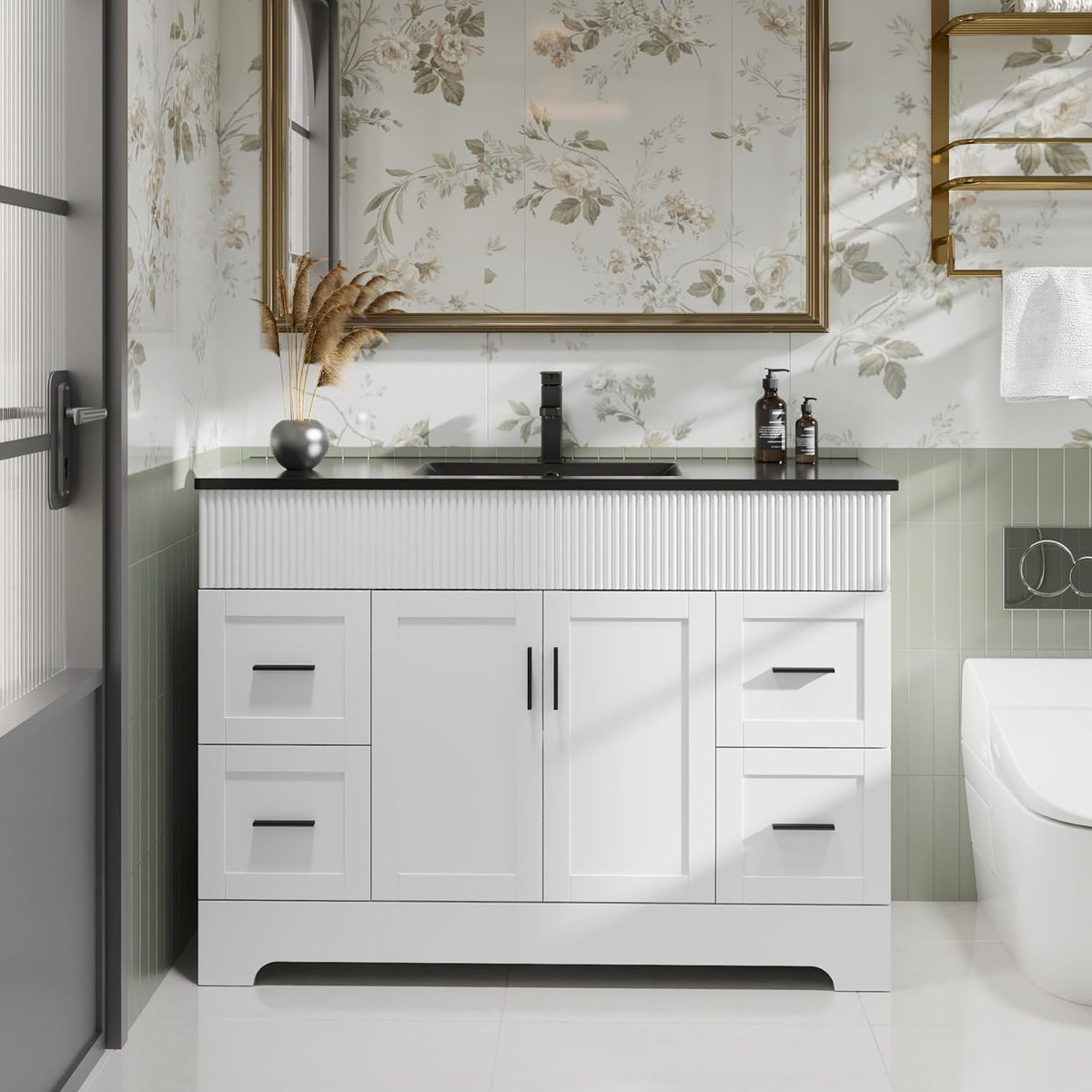 Front view of a single-sink white bathroom vanity with black countertop and ribbed upper apron.