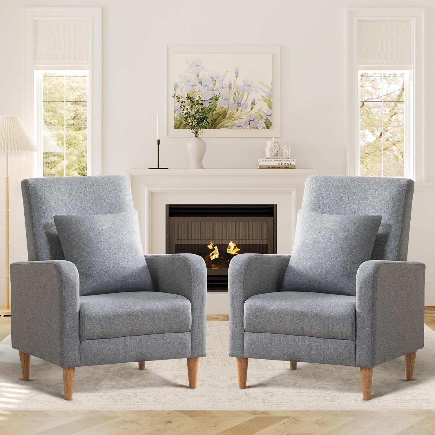 Pair of gray high-back upholstered chairs with removable square pillows and tapered wood legs in front of a fireplace.