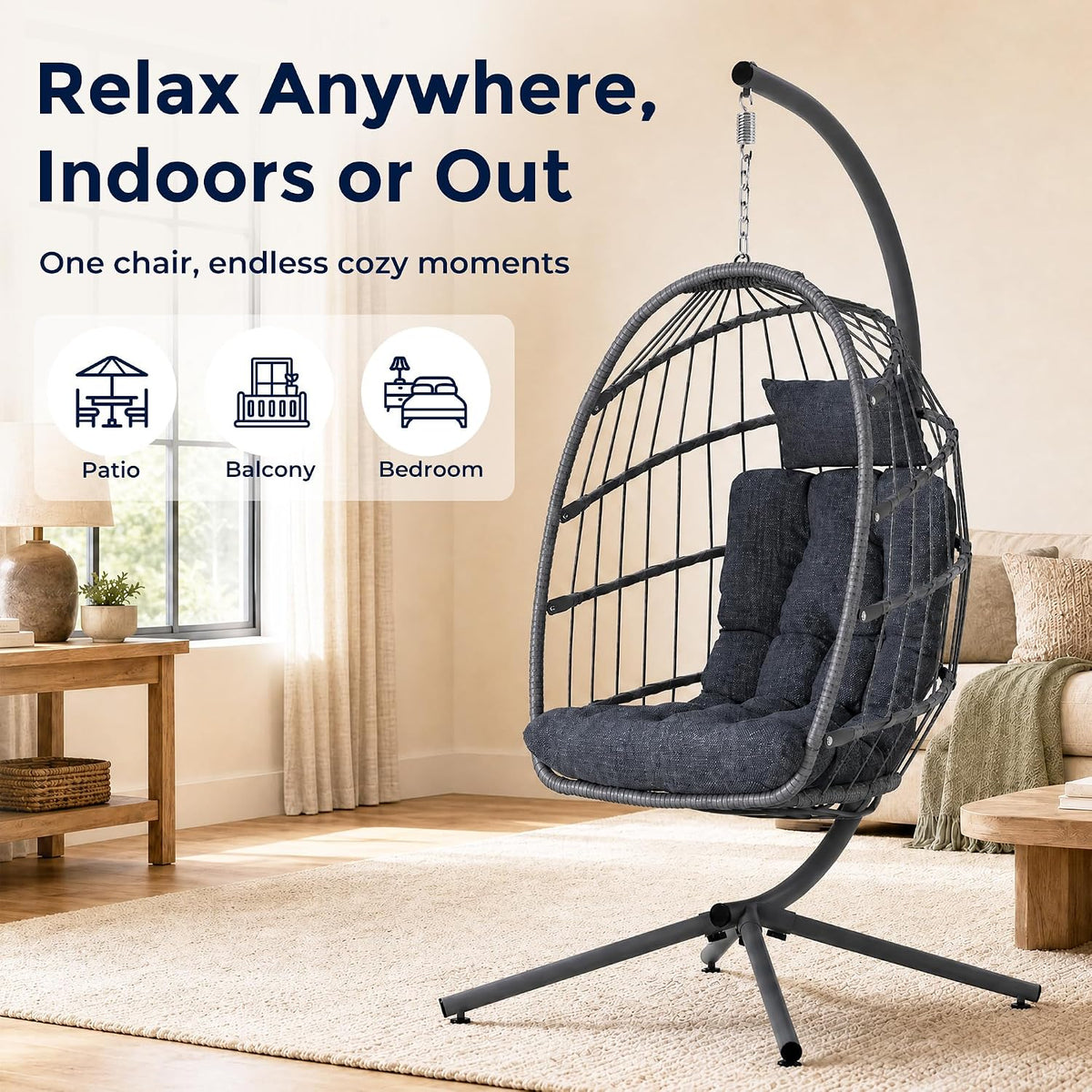 Freestanding grey egg swing chair with cushion hanging from curved stand in a bright living room.