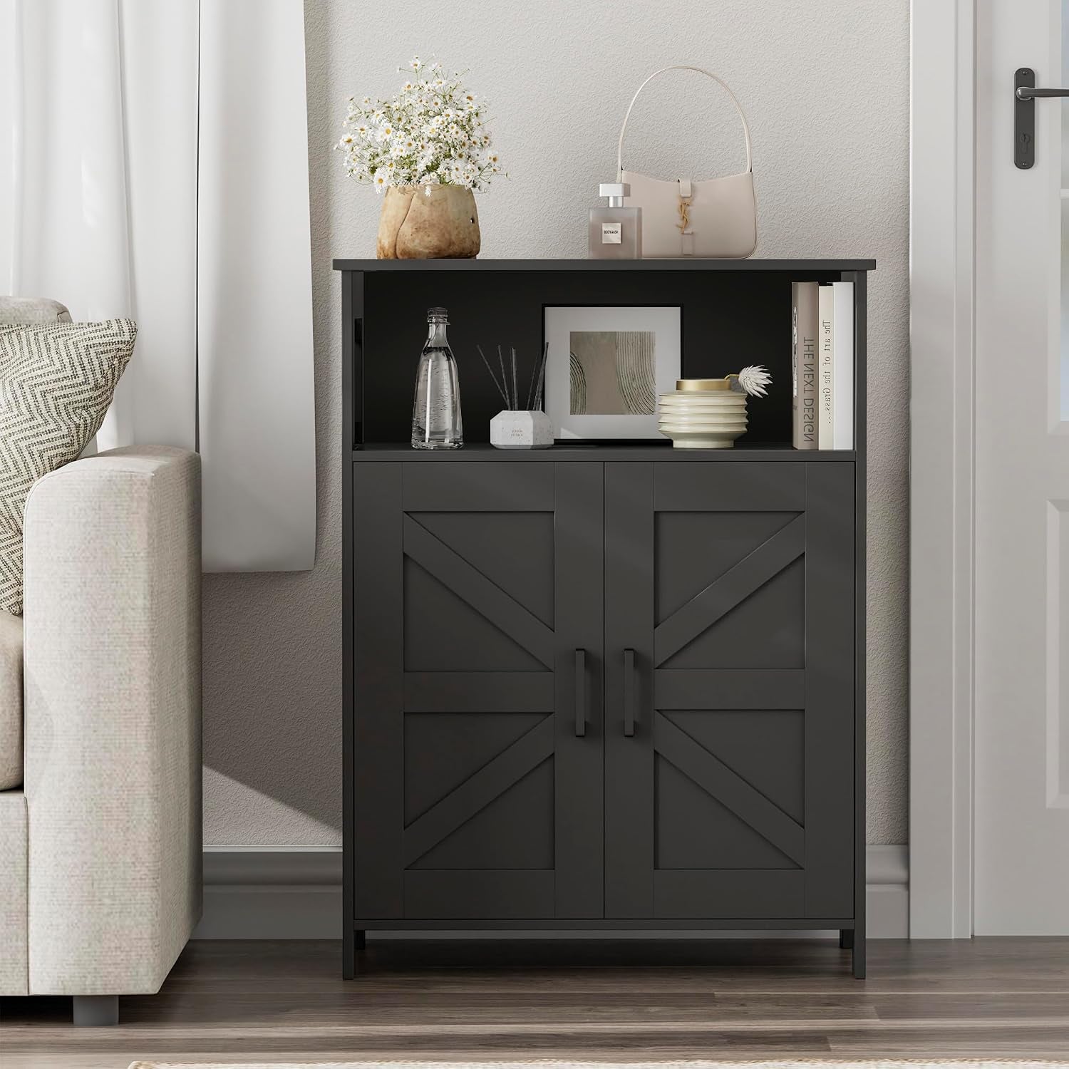 Black floor cabinet styled in a living space with decorative vase, books and small objects on the open shelf.