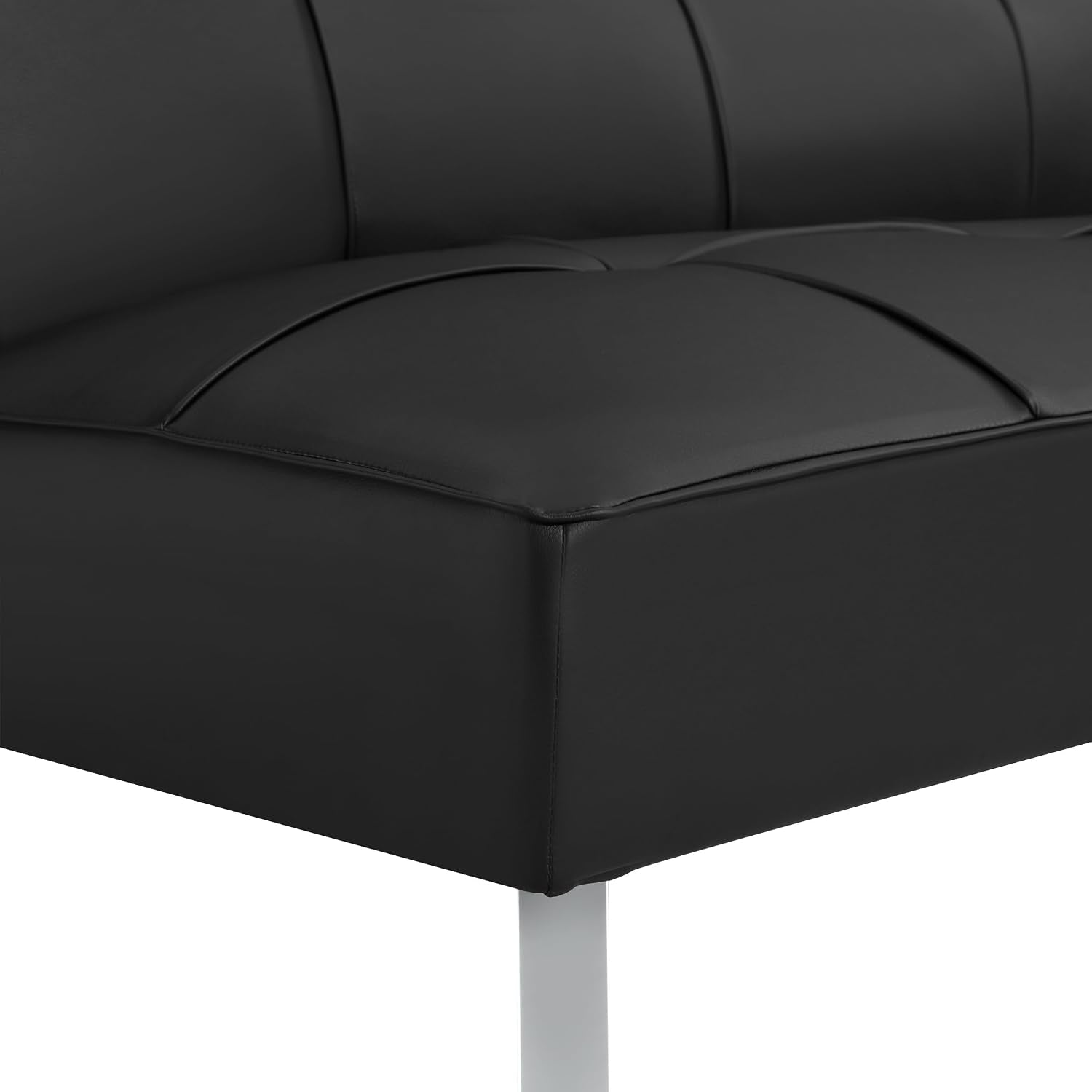 Close-up of black faux-leather seat corner showing tufted stitching and chrome leg