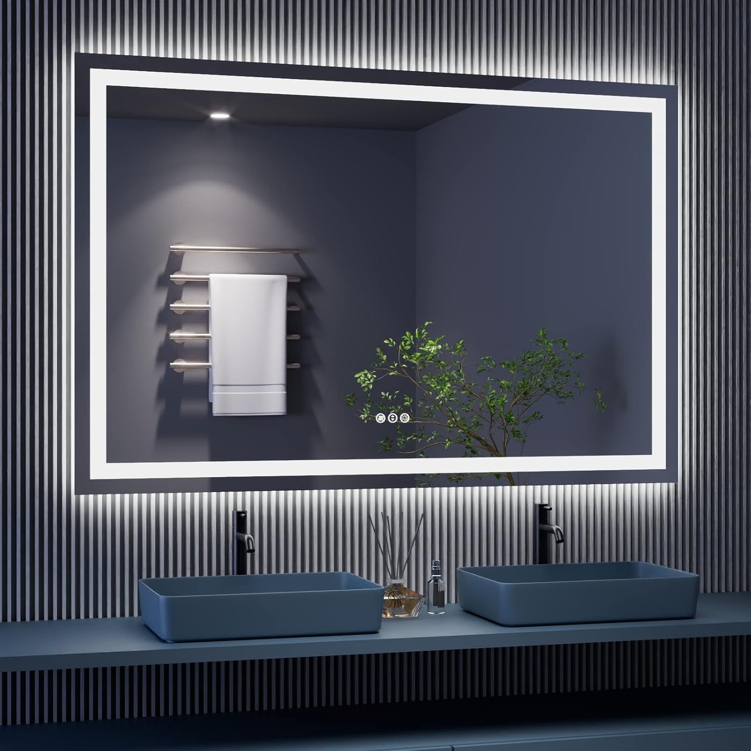 Wide rectangular LED mirror with illuminated inner and outer border above double sinks, towel rack and plant reflected.