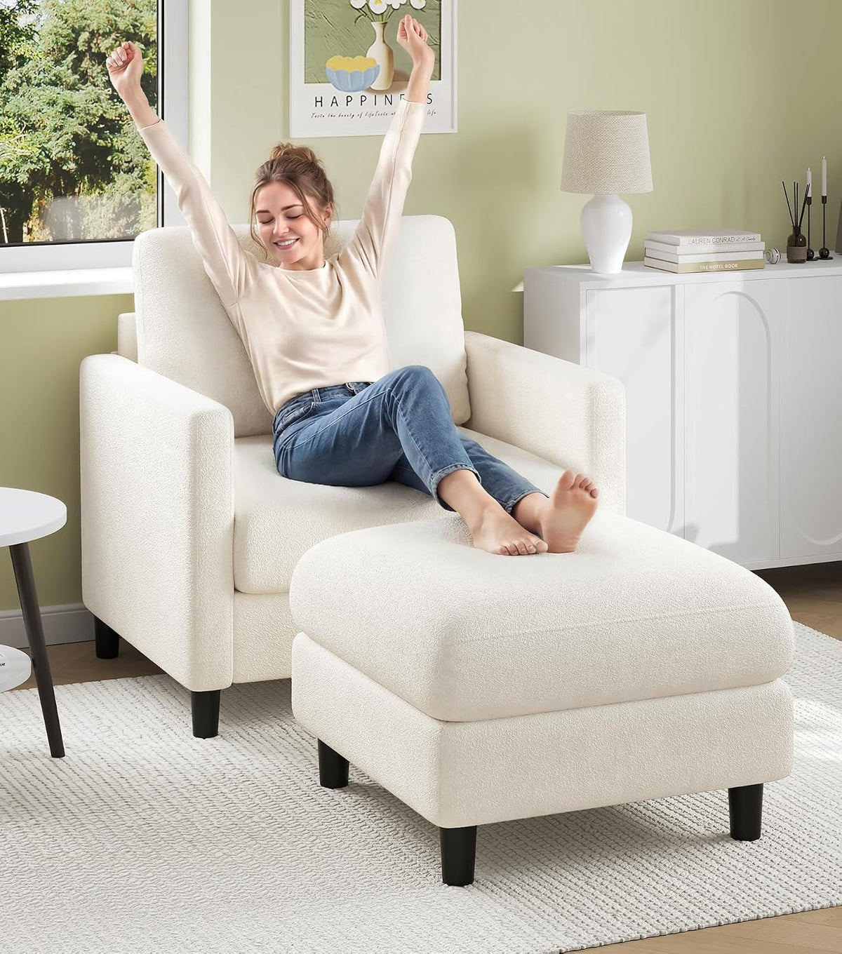 Off-white loveseat with matching ottoman in a bright room; woman relaxing with arms raised.