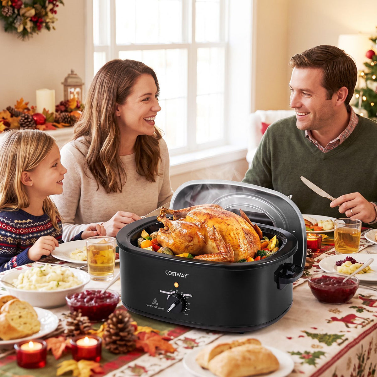 Black electric roaster with its lid open and a roasted turkey inside, set before a family at a holiday table.