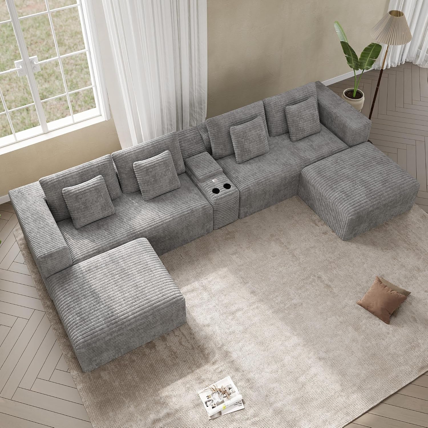 Top-down view of a light gray L-shaped modular sectional with chaise and built-in cup holder console