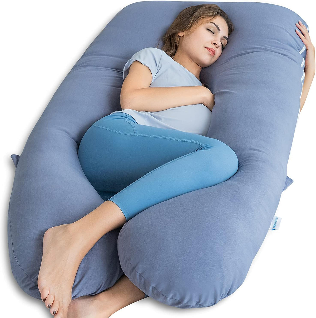 Blue U-shaped maternity body pillow with a woman cuddled inside, angled close-up showing leg and torso support