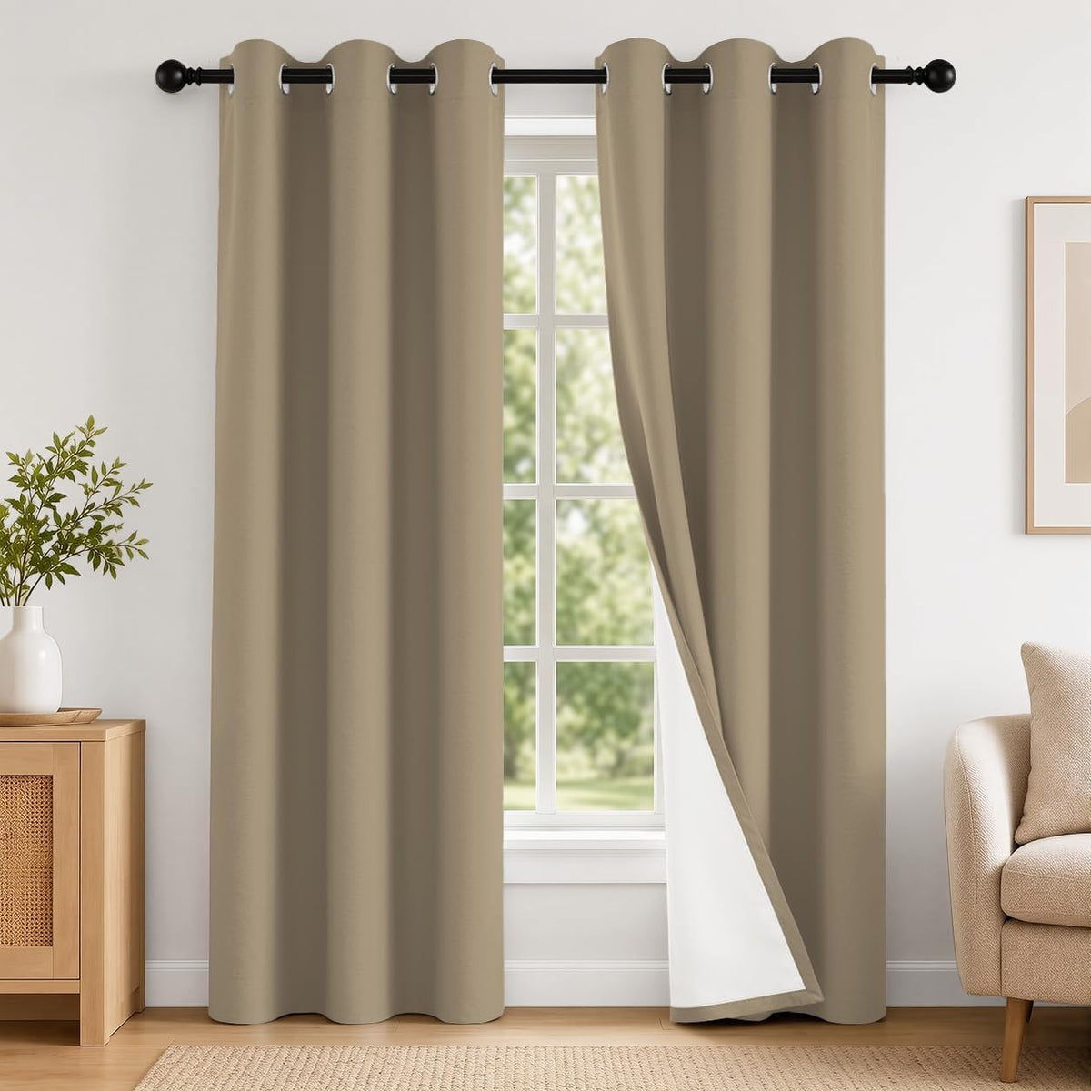 Pair of taupe grommet curtains hung over a window, one panel turned to show white backing