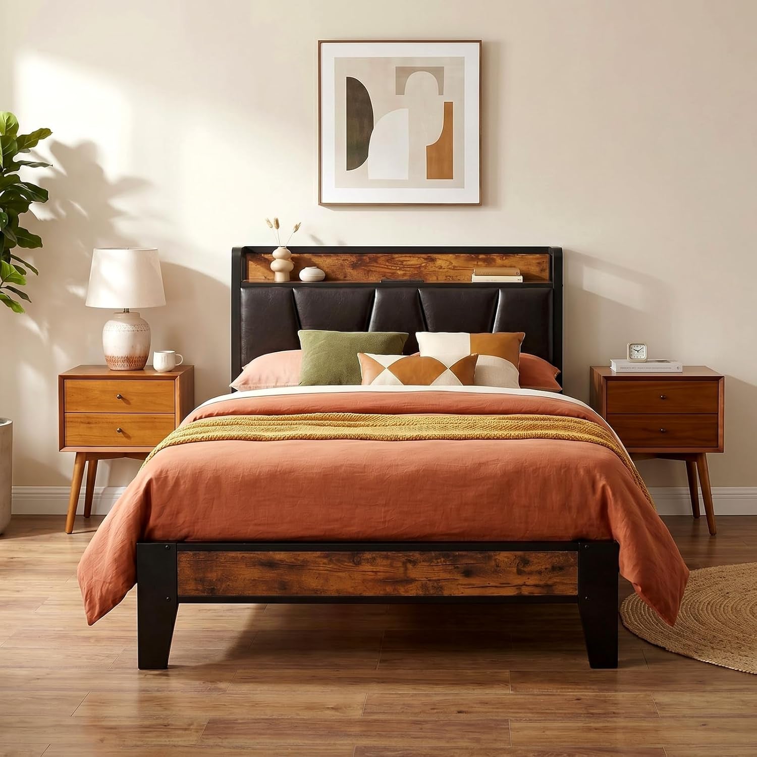 Centered view of bed with black tufted headboard, wood shelf trim and warm terracotta bedding.