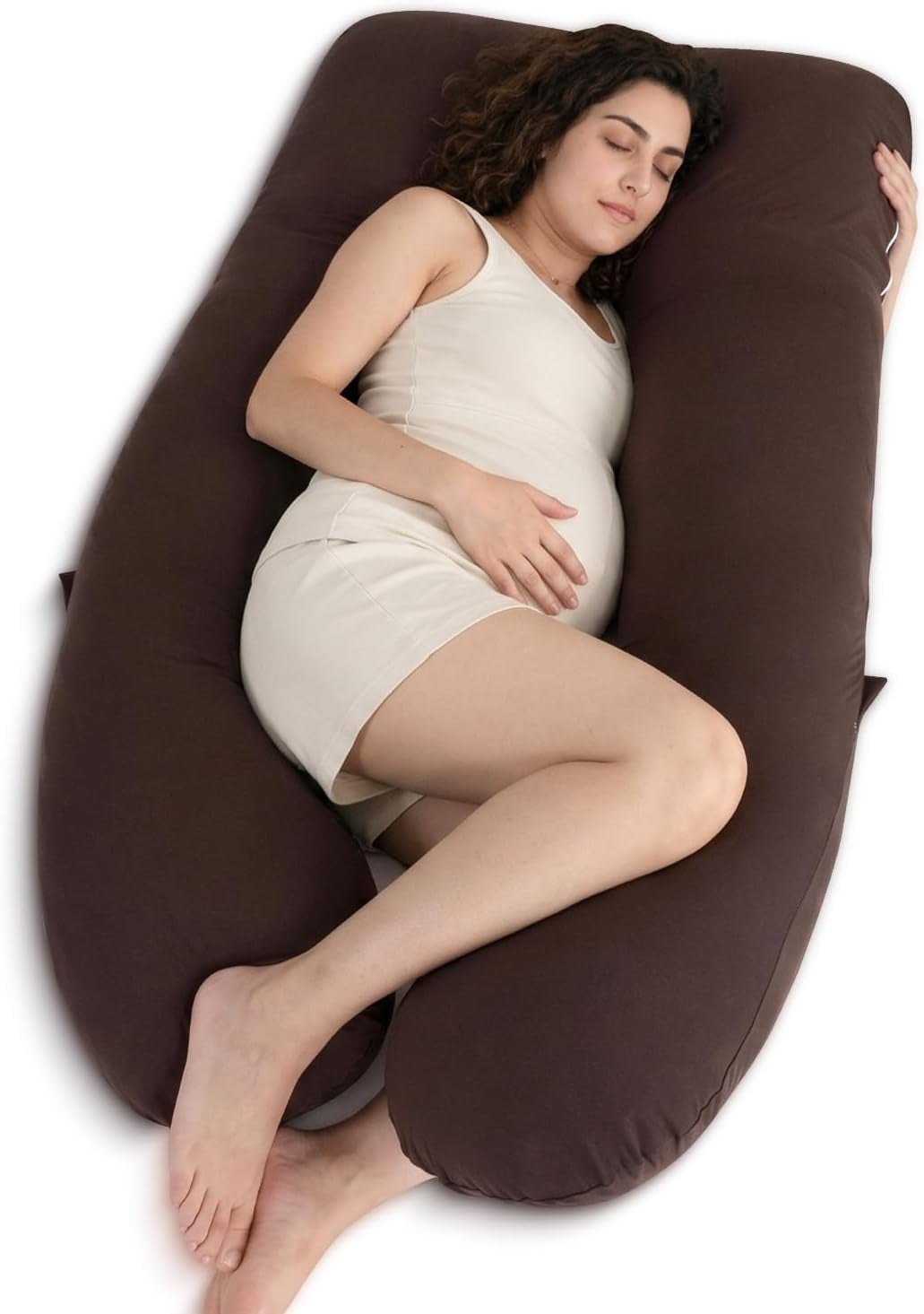 Overhead view of a pregnant woman sleeping curled inside a dark brown U-shaped body pillow