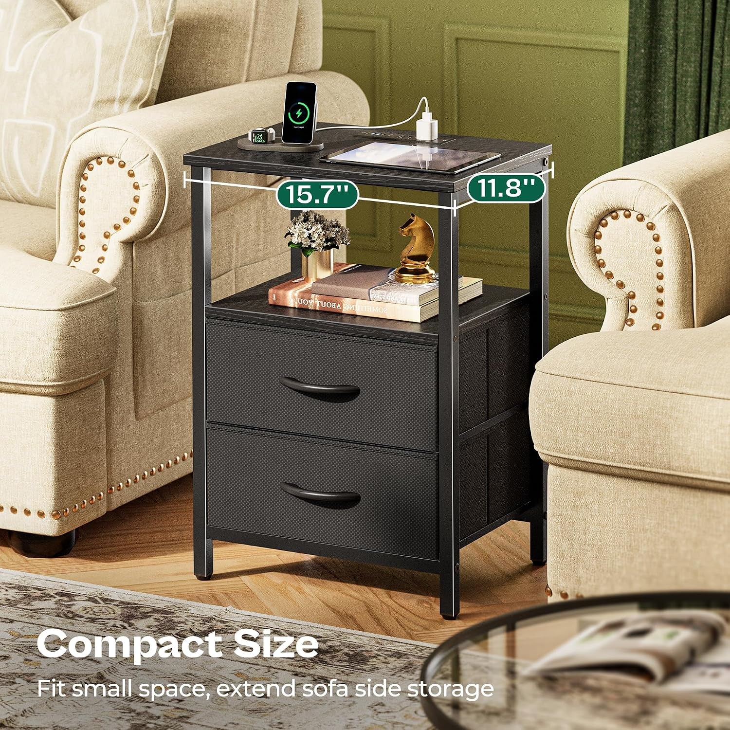 Three-quarter view of the nightstand between two upholstered armchairs with a phone and tablet on top and books on the