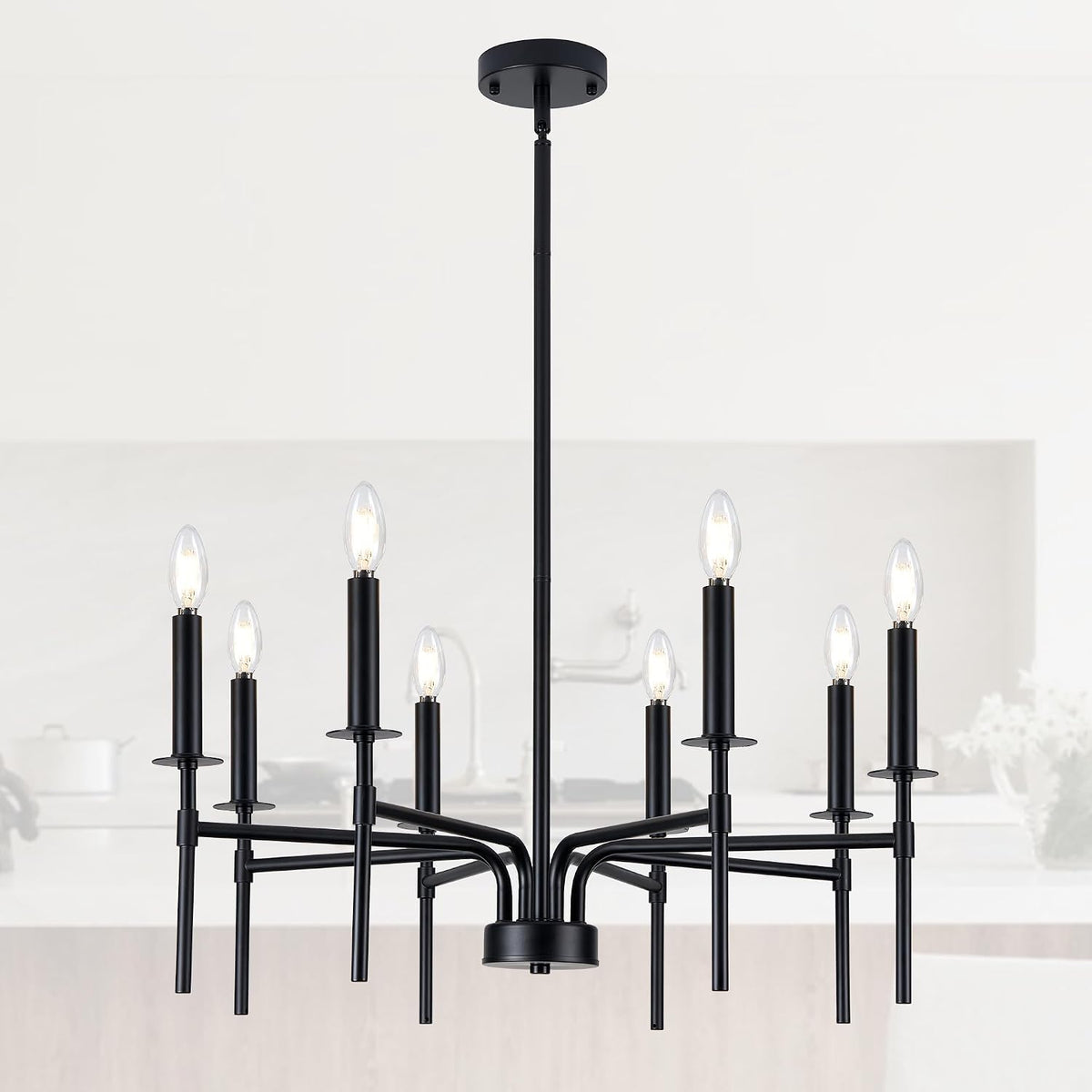 Close-up of black chandelier central rod and candle-style lamp holders in a bright kitchen backdrop.