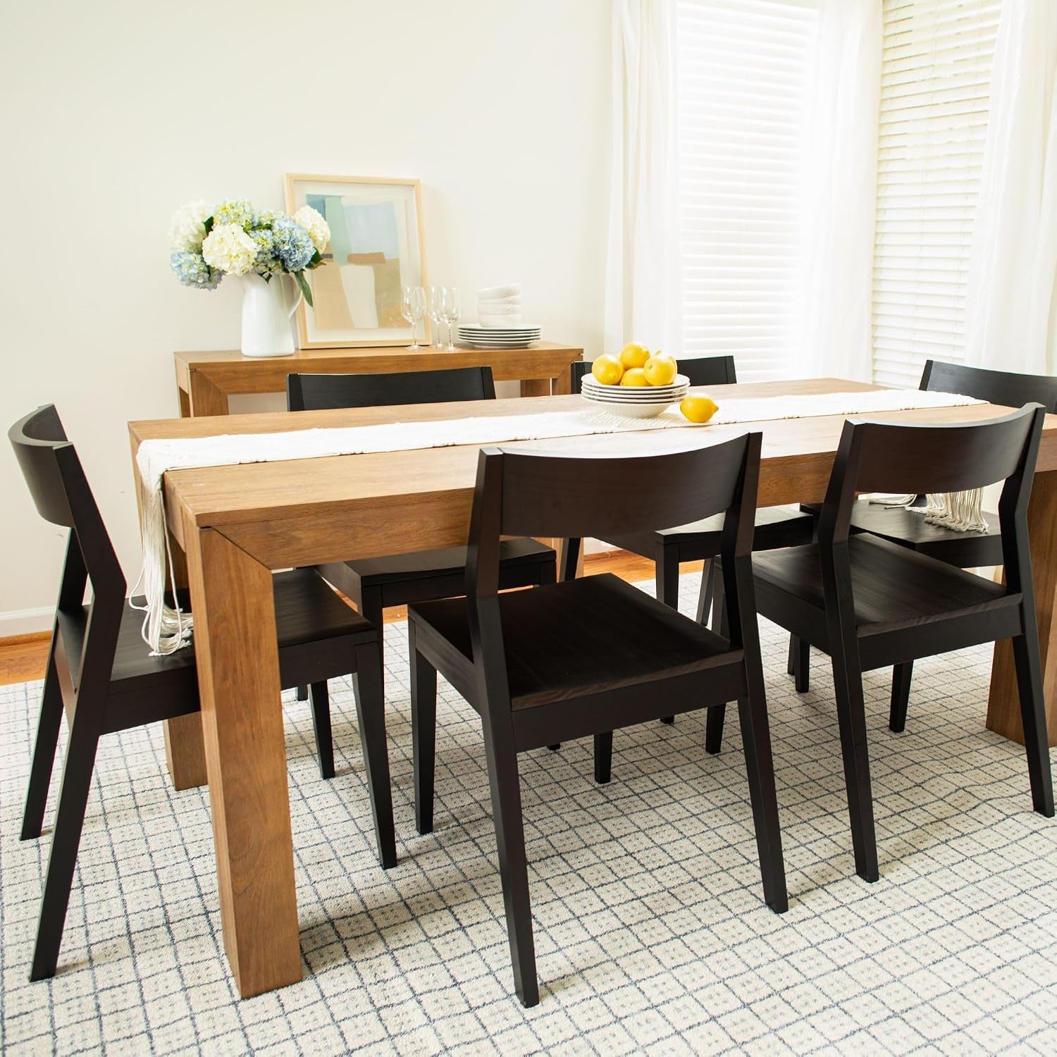 Dining room scene with the pine table set with dark wood chairs, a runner, and a bowl of lemons.