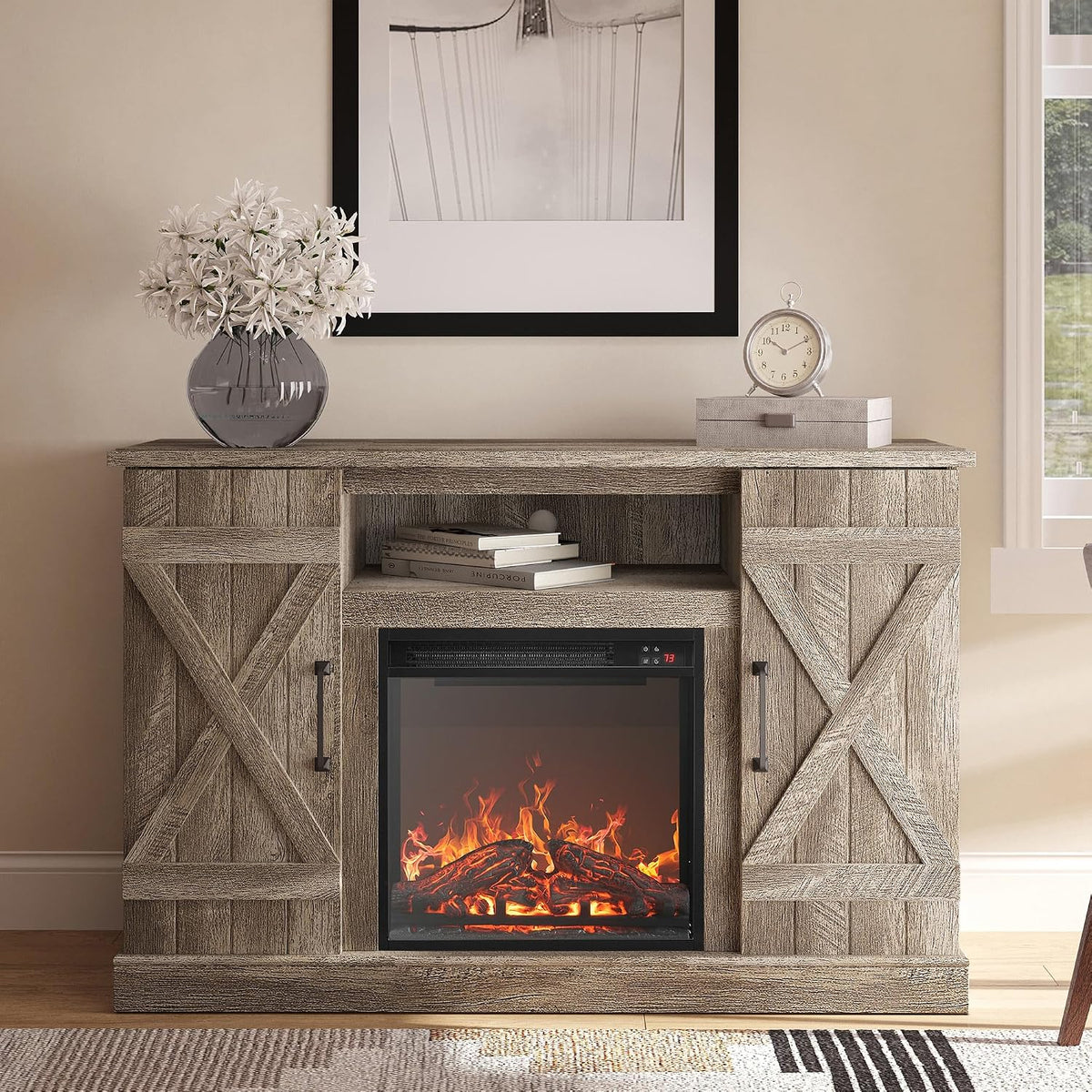 Close-up of the TV stand's upper shelf and barn-door paneling in Ashland Pine finish with decorative vase and stacked books