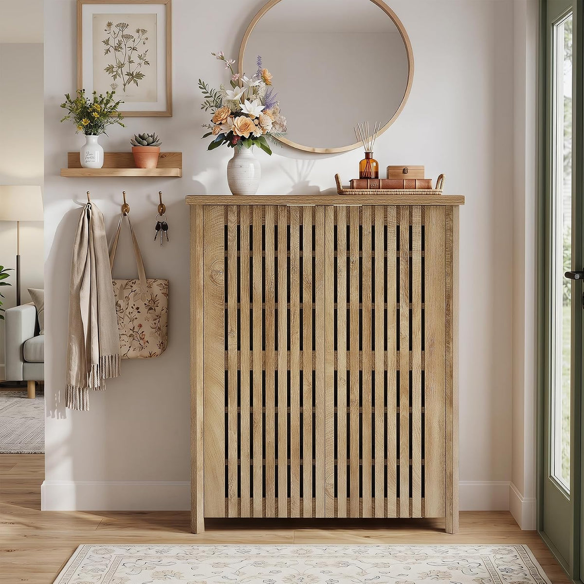 Front view of shoe cabinet in an entryway with round mirror and decor on top