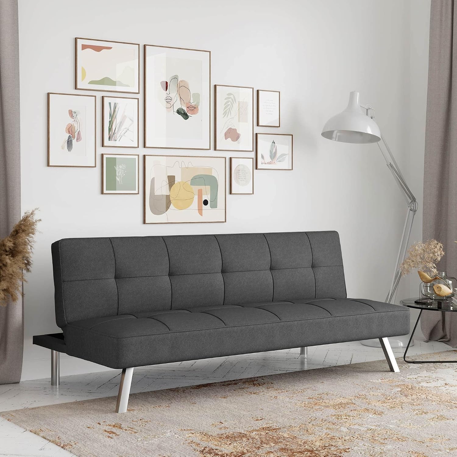 Charcoal tufted convertible sofa angled front view with chrome legs in a styled living room