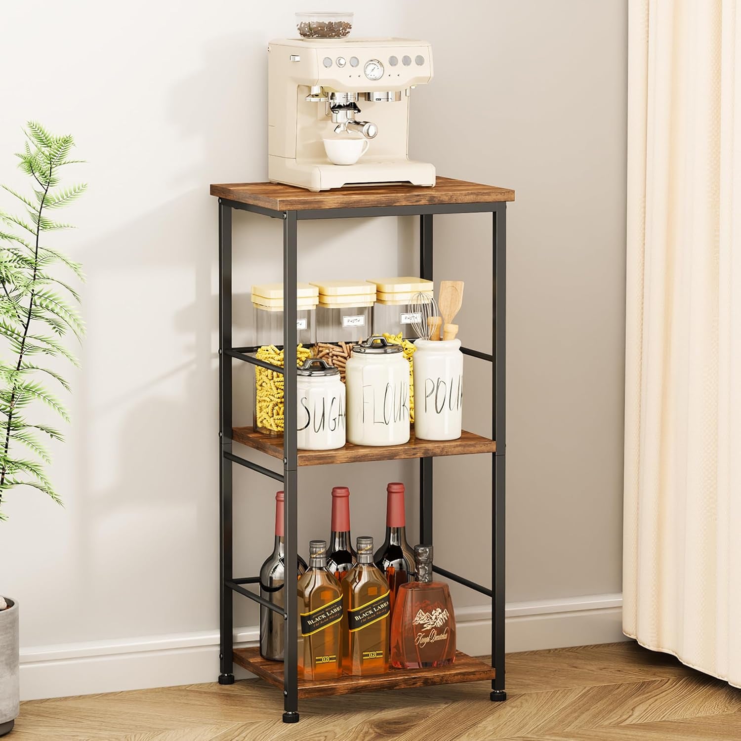 Narrow three-shelf baker's rack with black metal frame and wood shelves holding jars and bottles