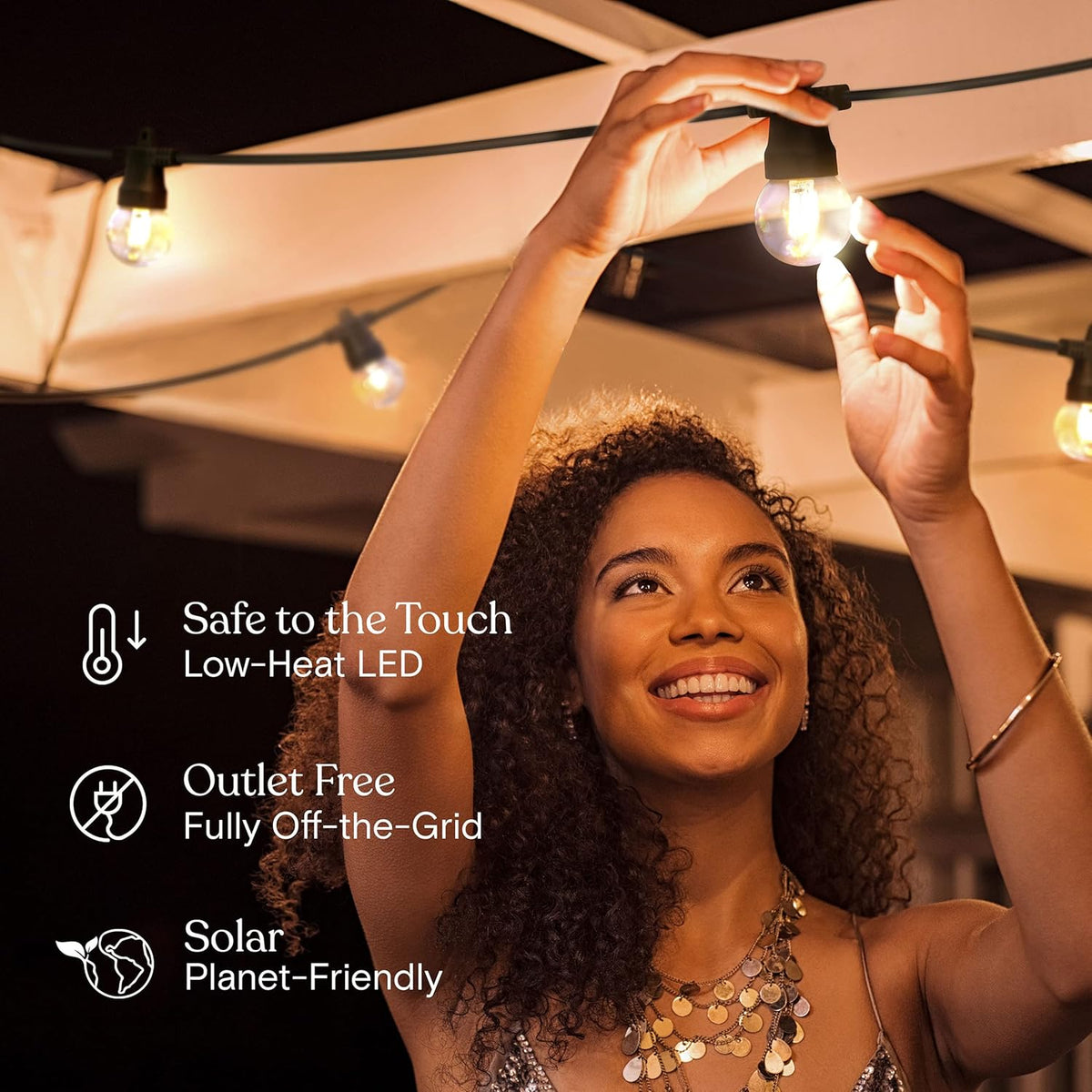 Woman installing warm-white string lights under a canopy at night to show outlet-free solar-powered use