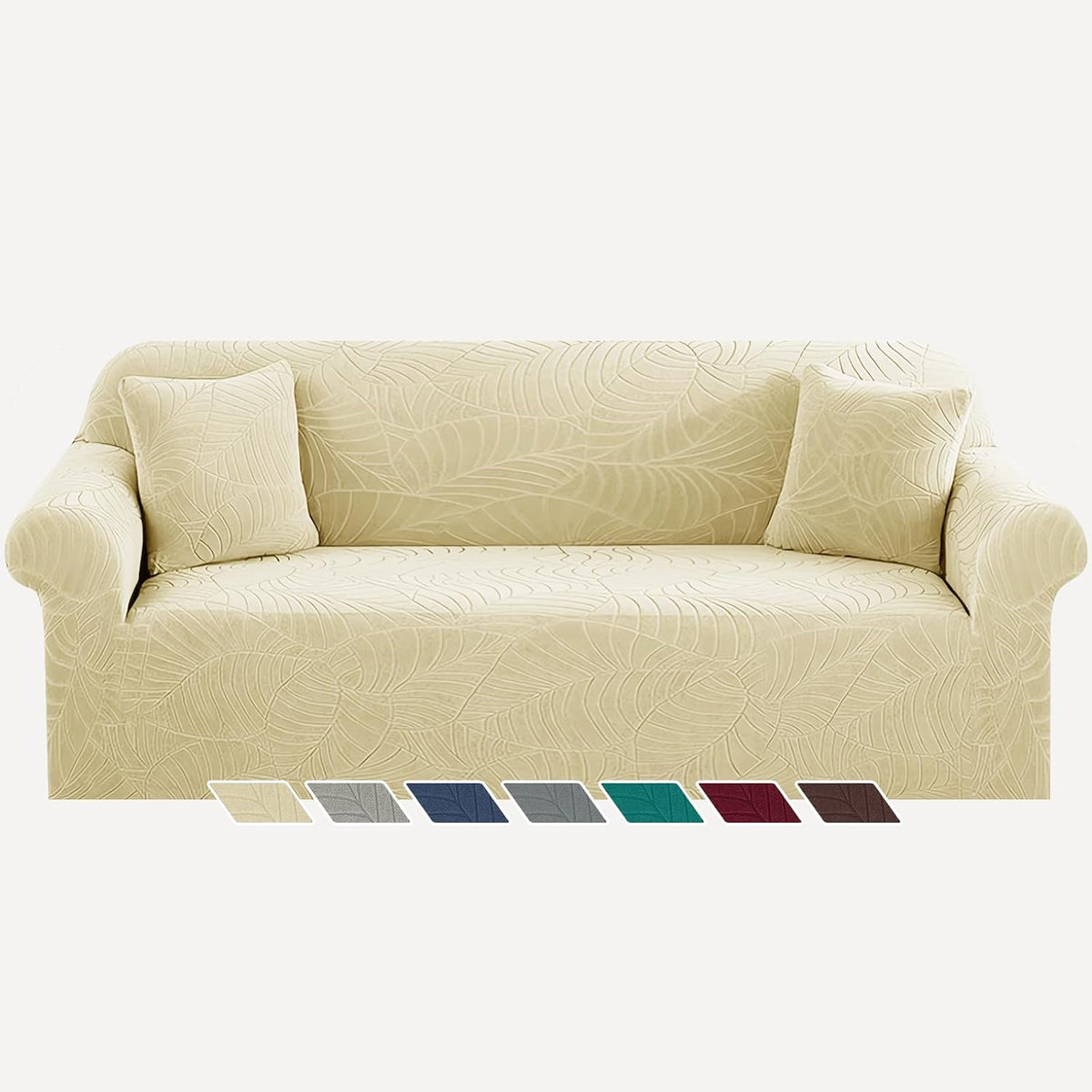 Three-seat sofa dressed in cream leaf-pattern stretch slipcover with two matching throw pillows