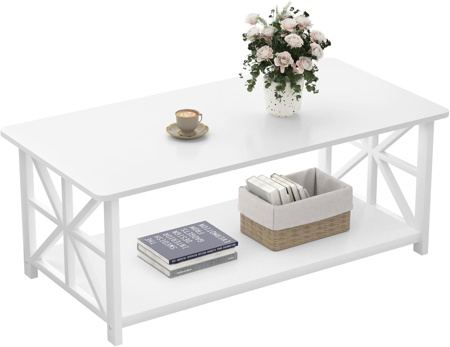 All-white rectangular coffee table with X-shaped side supports and a lower shelf, shown with books and a flower vase.