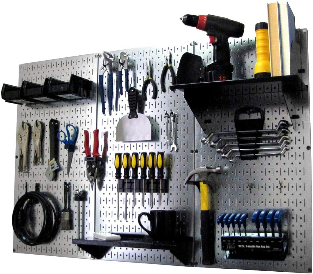 Silver metal pegboard mounted with tools, a drill, shelf and wrench set on a white background.