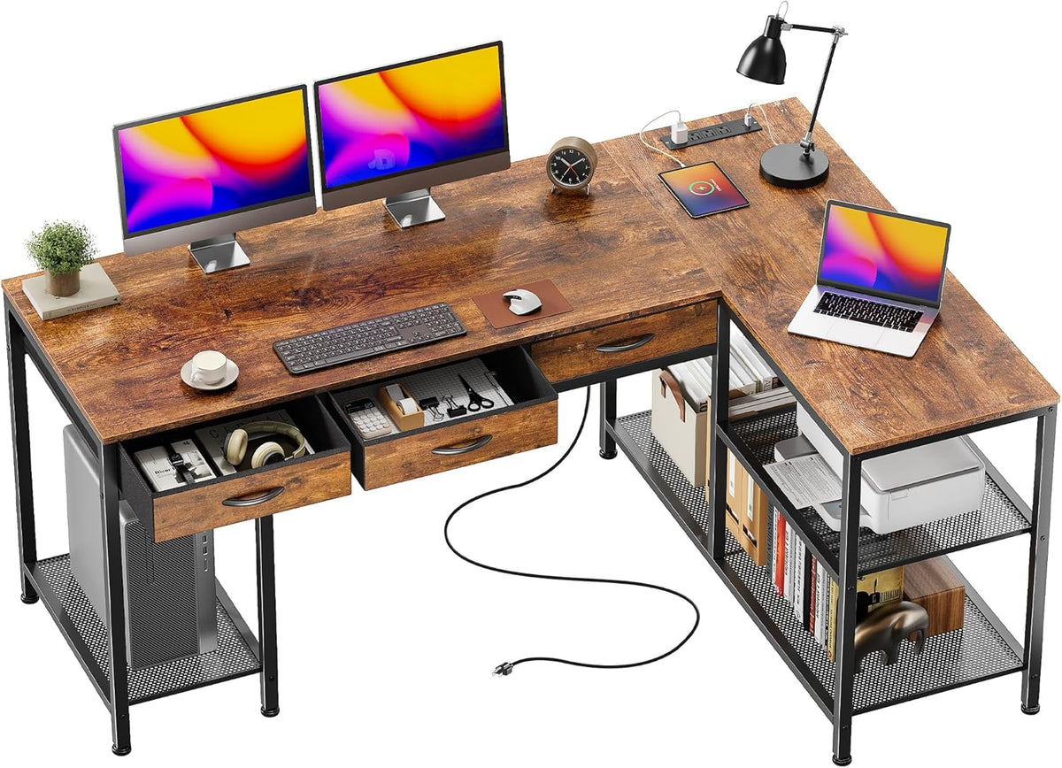 Top-down view of the desk with three drawers open, dual monitors on the desktop and the built-in power strip visible